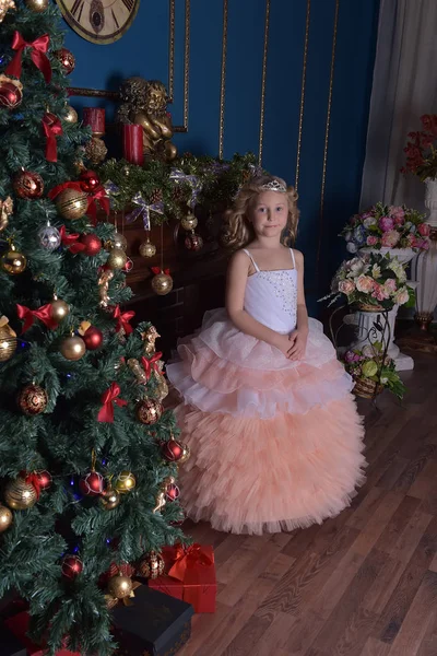 クリスマスツリーの近くにクリスマスにピンクのドレスを着た白い女の子 — ストック写真