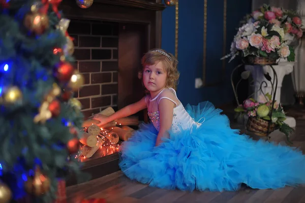 Meisje Een Blauwe Jurk Door Een Gloeiende Haard Met Kerstmis — Stockfoto