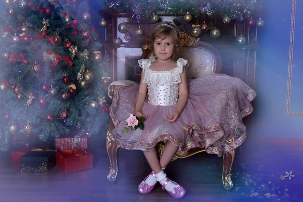 Girl in white with pink dress sitting in chair near Christmas tr — Stock Photo, Image