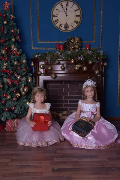 Две Сестры Белом Розовым Платьем Сидят Подарками Руках Рождество — стоковое фото