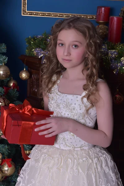 Menina em um vestido branco inteligente em uma árvore de Natal — Fotografia de Stock