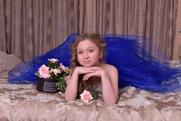 Молода принцеса в синій вечірній сукні з трояндами — стокове фото