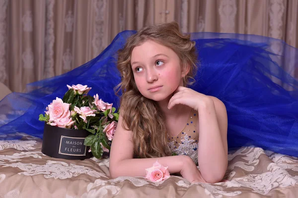 Jovem princesa em um vestido de noite azul com rosas — Fotografia de Stock