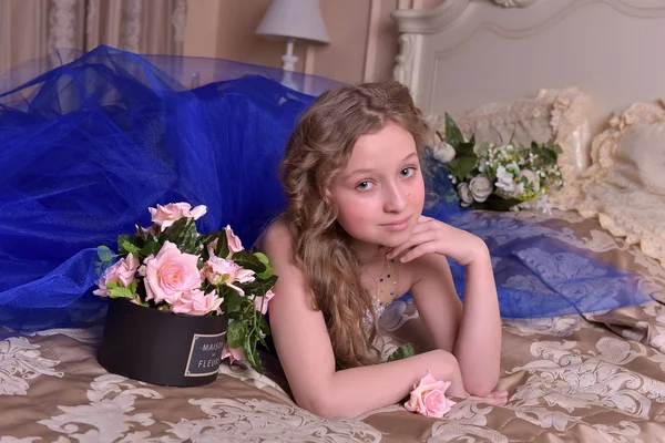 Junge Prinzessin in einem blauen Abendkleid mit Rosen — Stockfoto