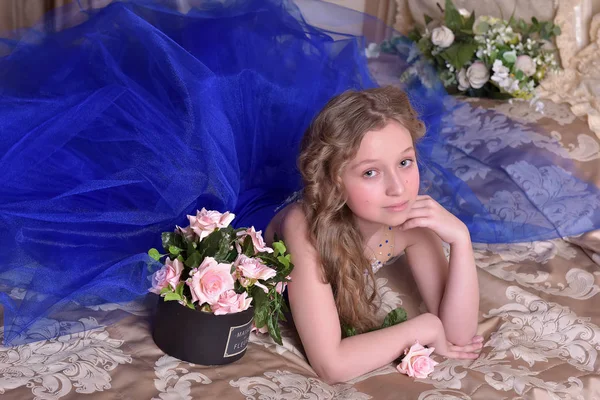 Jovem princesa em um vestido de noite azul com rosas — Fotografia de Stock