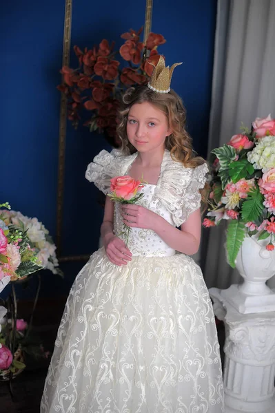 Prinsesse i hvid kjole med krone på hovedet og blomster - Stock-foto