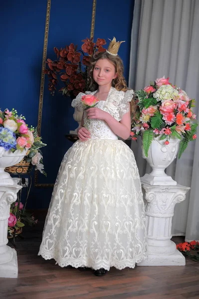 Princesa en un vestido blanco con una corona en la cabeza y flores —  Fotos de Stock