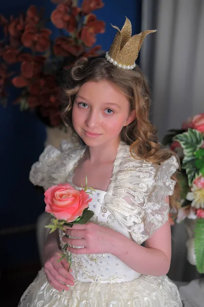 Prinzessin im weißen Kleid mit Krone auf dem Kopf und Blumen — Stockfoto