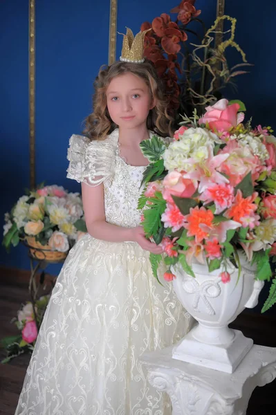 Principessa in abito bianco con una corona sulla testa e fiori — Foto Stock