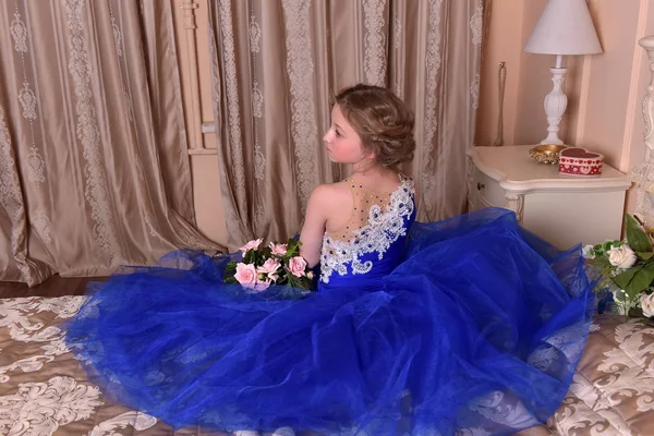 青いドレスの若い王女は ros の花束と座っています。 — ストック写真