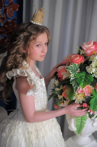 Prinzessin im weißen Kleid mit Krone auf dem Kopf und Blumen — Stockfoto