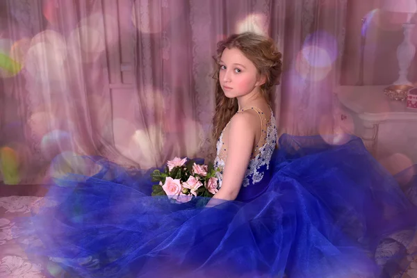 Young princess in a blue dress is sitting  with a bouquet of ros — Stock Photo, Image