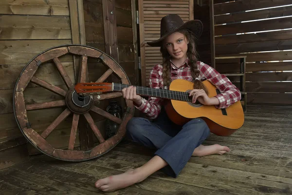 A girl in a cowboy hat and plaid shirt — Stock Photo, Image