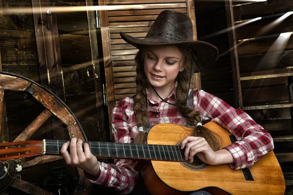 A girl in a cowboy hat and plaid shirt — Stock Photo, Image