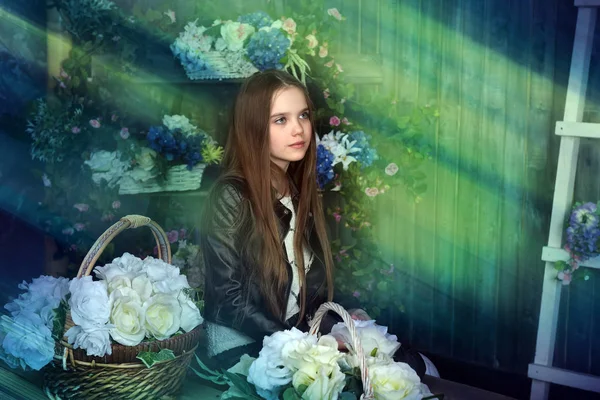 Mladá dívka v černé kožené bundě s květinami — Stock fotografie