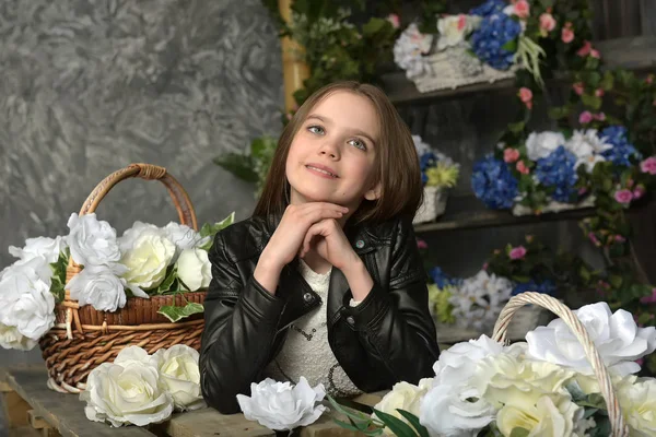 Mladá dívka v černé kožené bundě s květinami — Stock fotografie