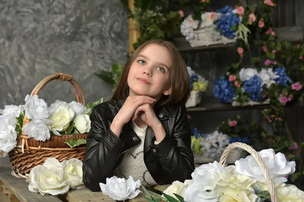 Niña en una chaqueta de cuero negro con flores —  Fotos de Stock