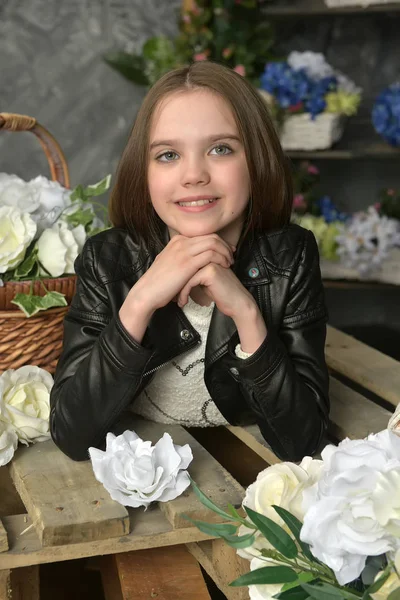 Niña en una chaqueta de cuero negro con flores —  Fotos de Stock