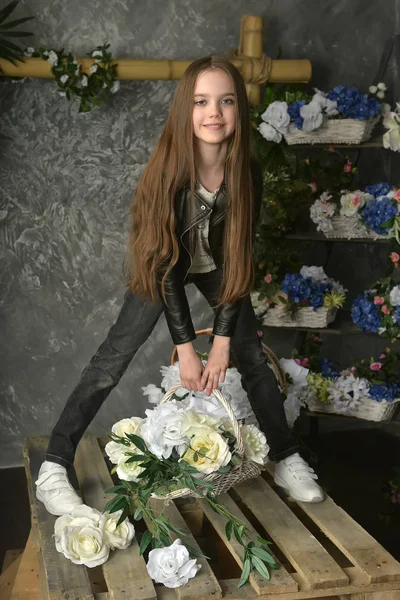 Νεαρό κορίτσι σε ένα μαύρο δερμάτινο σακάκι με λουλούδια — Φωτογραφία Αρχείου