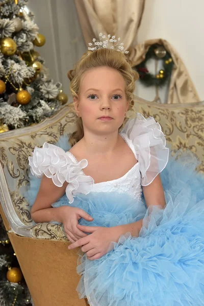Prenses mavi zarif elbise ile beyaz bir koltukta oturur — Stok fotoğraf