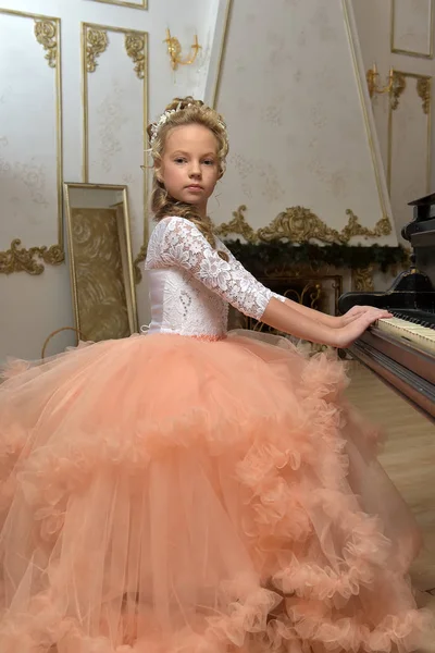 Retrato de uma princesa em vestido de pêssego no piano — Fotografia de Stock