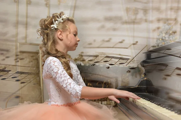 Porträtt av en prinsessa i peach klä på pianot — Stockfoto