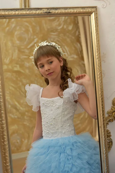 Menina em branco com vestido festivo azul, no espelho — Fotografia de Stock