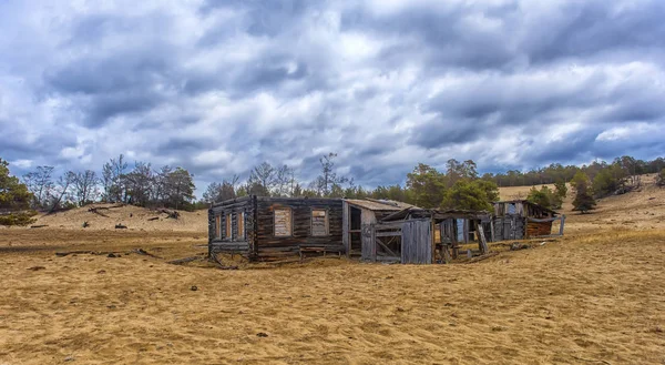 Las ruinas de una casa de madera en la playa de arena — Foto de Stock