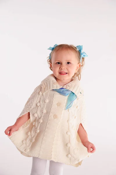 Little girl in a woolen knitted wrap - poncho on a white backgro — Stock Photo, Image