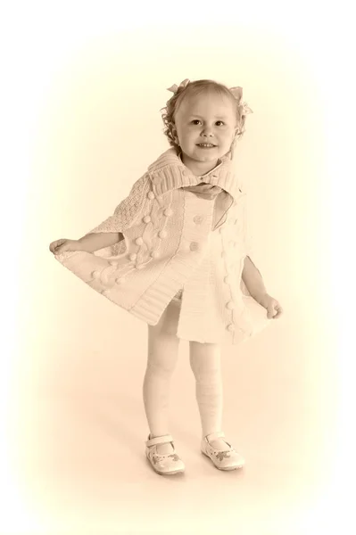 Niña en una envoltura de punto de lana - poncho en un fondo blanco — Foto de Stock