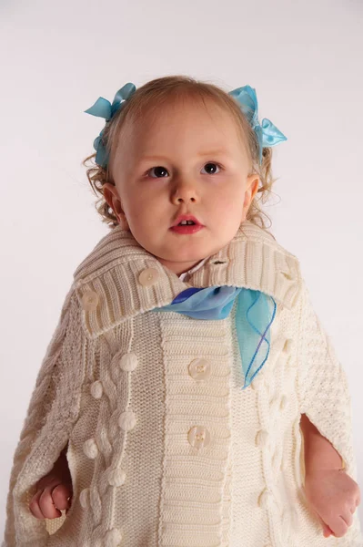 Little girl in a woolen knitted wrap - poncho on a white backgro — ストック写真