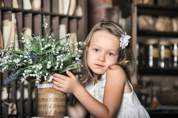 スタジオで花束を持った白いドレスを着た女の子の肖像画です — ストック写真