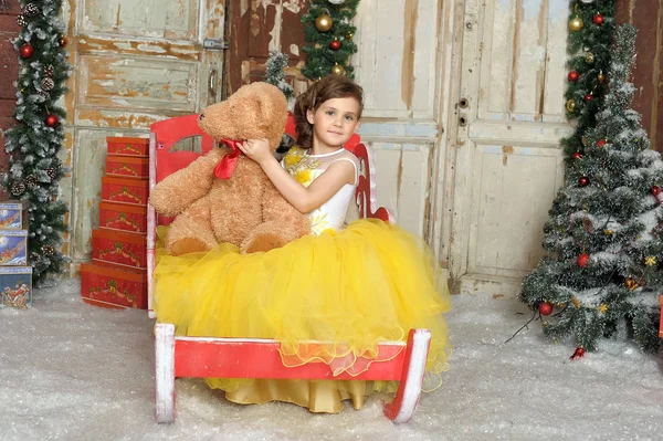 Girl in elegant yellow dress with a teddy bear, christmas — Stock Photo, Image