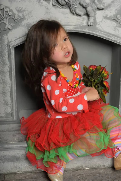 Fille enfant, dans un rouge avec une robe verte avec un bouquet de fl rouge — Photo