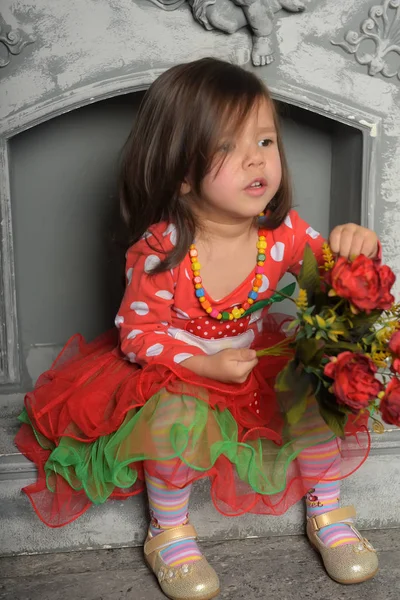Fille enfant, dans un rouge avec une robe verte avec un bouquet de fl rouge — Photo