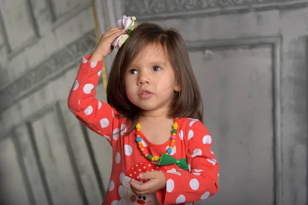 小さなブルネットの女の子で赤いエンドウ豆のドレス — ストック写真