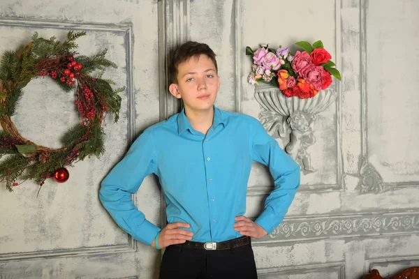 Adolescente menino em camisa azul no Natal na porta com o Natal — Fotografia de Stock
