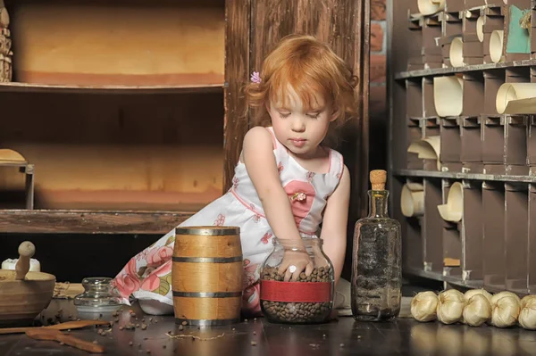 Red-haired girl sitting plays in the vintage kitchen — Stock Photo, Image