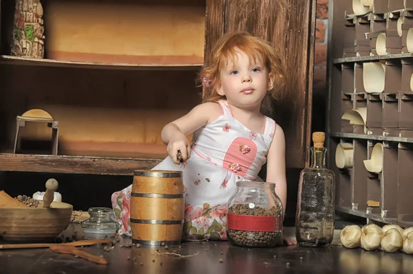 Red-haired girl sitting plays in the vintage kitchen — Stock Photo, Image