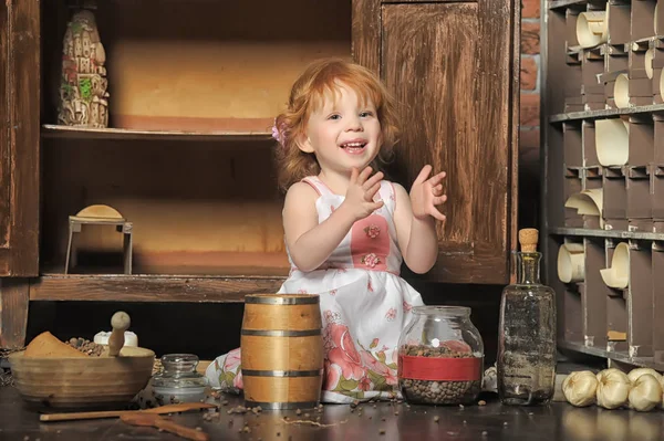 Red-haired girl sitting plays in the vintage kitchen — Stock Photo, Image