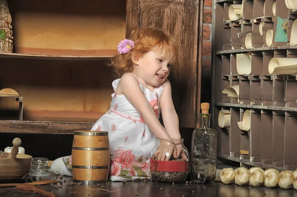 Chica pelirroja sentado juega en la cocina vintage —  Fotos de Stock