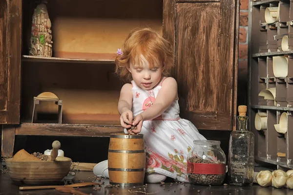 Red-haired girl sitting plays in the vintage kitchen — Stock Photo, Image