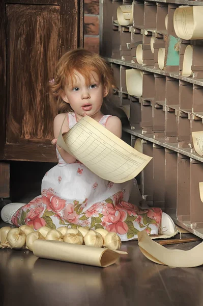 Rödhårig flicka med ett pappersark i händerna i en vintage — Stockfoto