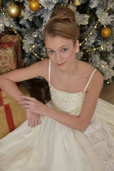 Bela jovem com penteado à noite em um vestido branco por — Fotografia de Stock