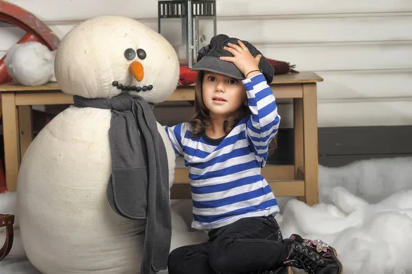 Flicka med en leksak snögubbe. — Stockfoto