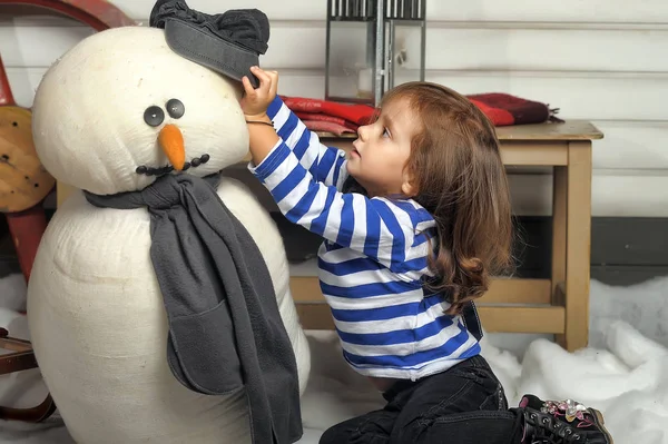 Menina com um boneco de neve de brinquedo . — Fotografia de Stock