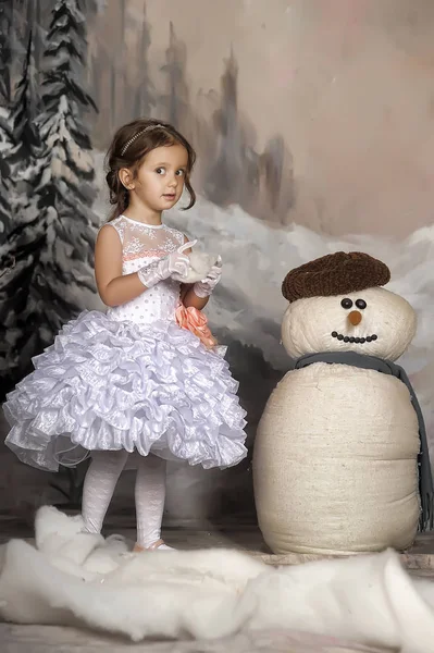 Meisje met een speelgoed sneeuwpop. Kerstmis, cadeau. — Stockfoto