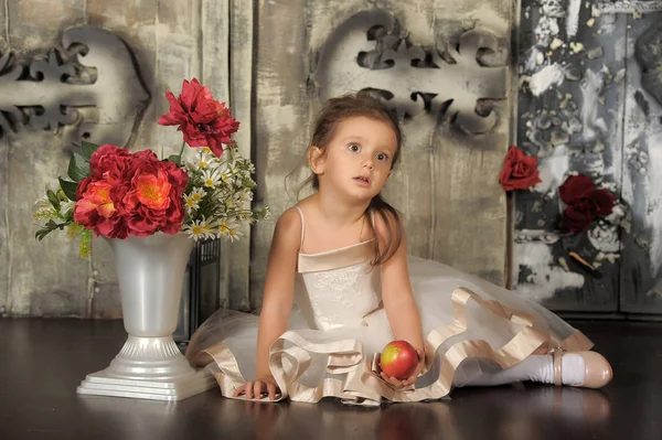 Mała szczęśliwa księżniczka dziewczyna siedzi, wazon z kwiatami. — Zdjęcie stockowe