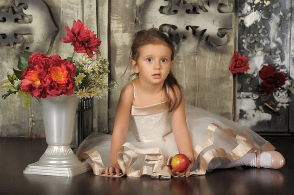 Kleine glückliche Prinzessin Mädchen sitzend, Vase mit Blumen. — Stockfoto