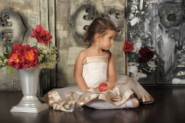 Klein gelukkig prinses meisje zitten, vaas met bloemen. — Stockfoto